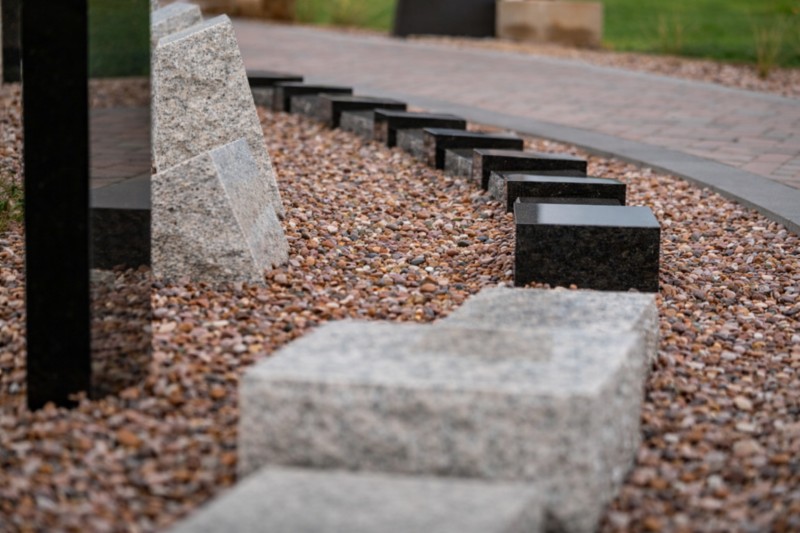 Granite memorial curbing with black granite markers on pebble bed, Direct Cremation Gilbert, AZ