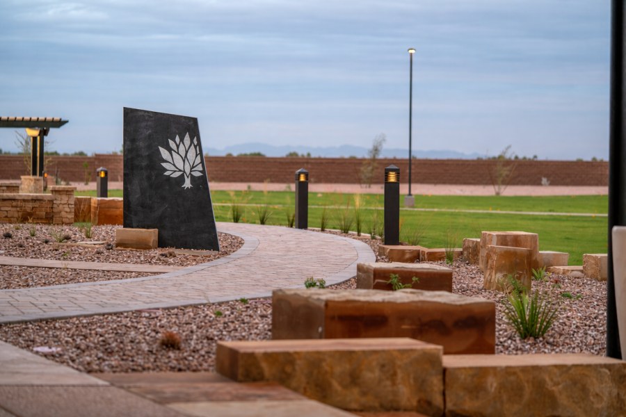 Direct Cremations Gilbert, AZ memorial garden with curved walkway, black stone monument and landscape lighting.